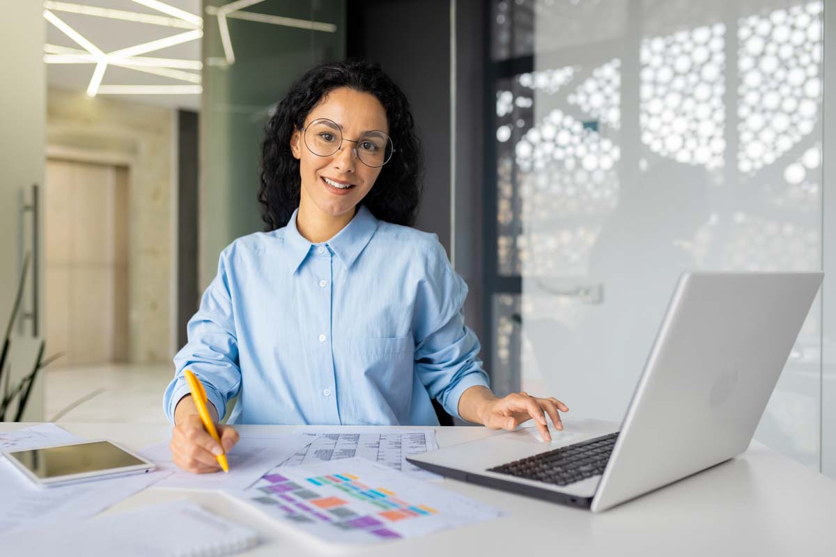 Woman on laptop with sheets printed out