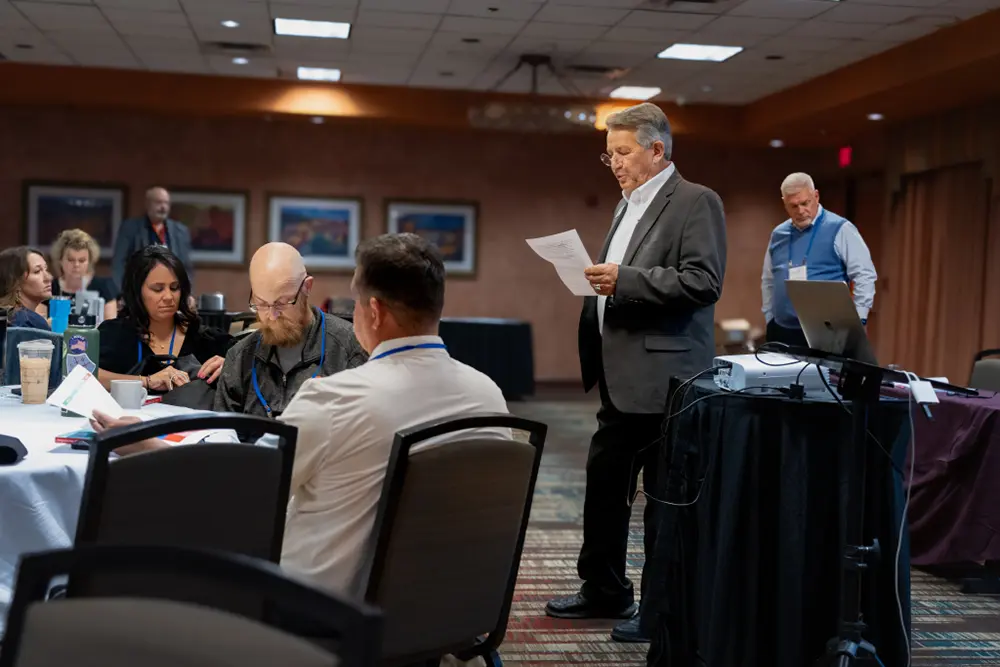 Speaker reading the paper to attendees at conference