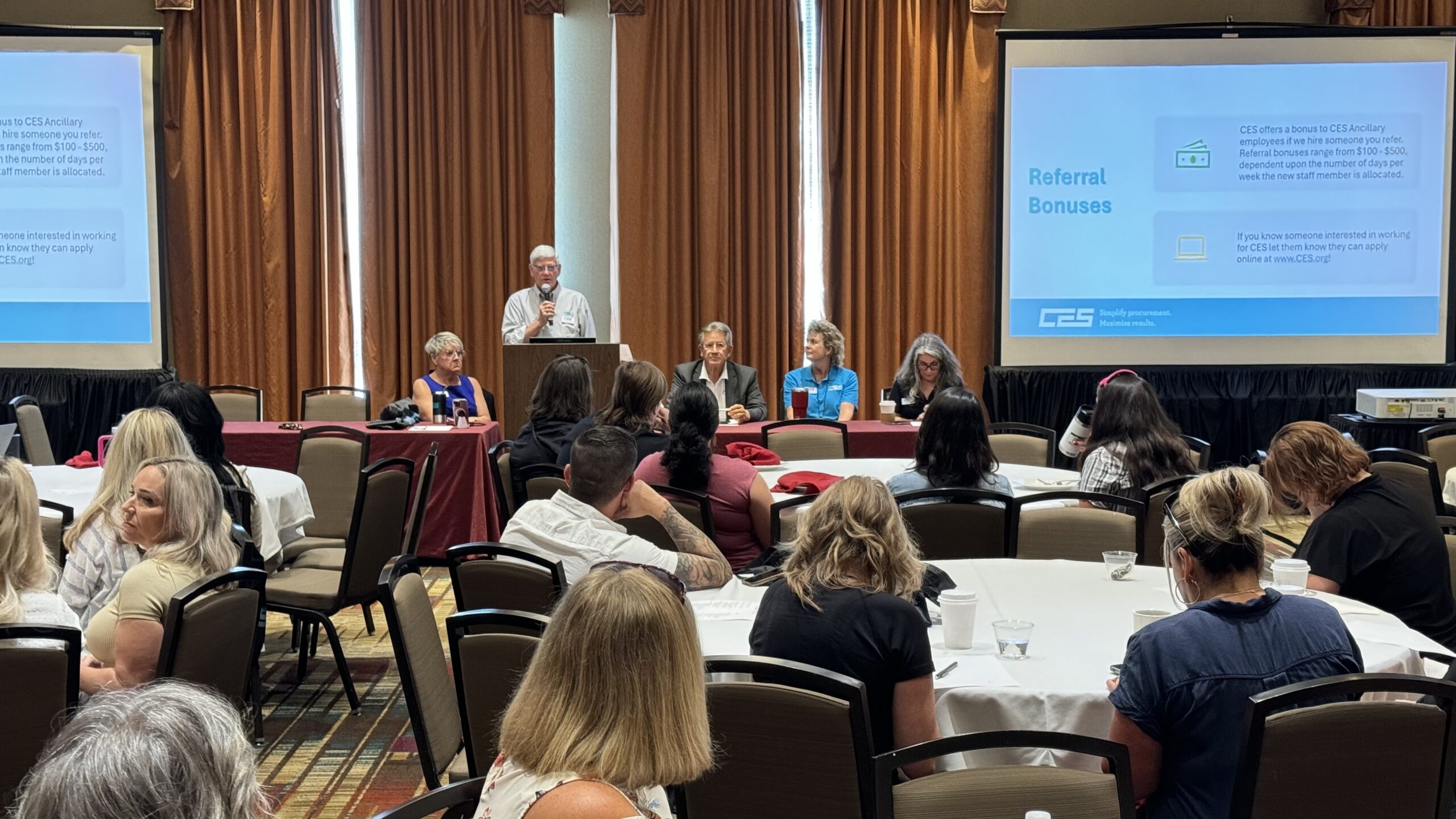 Meeting room of people with presenter at the podium