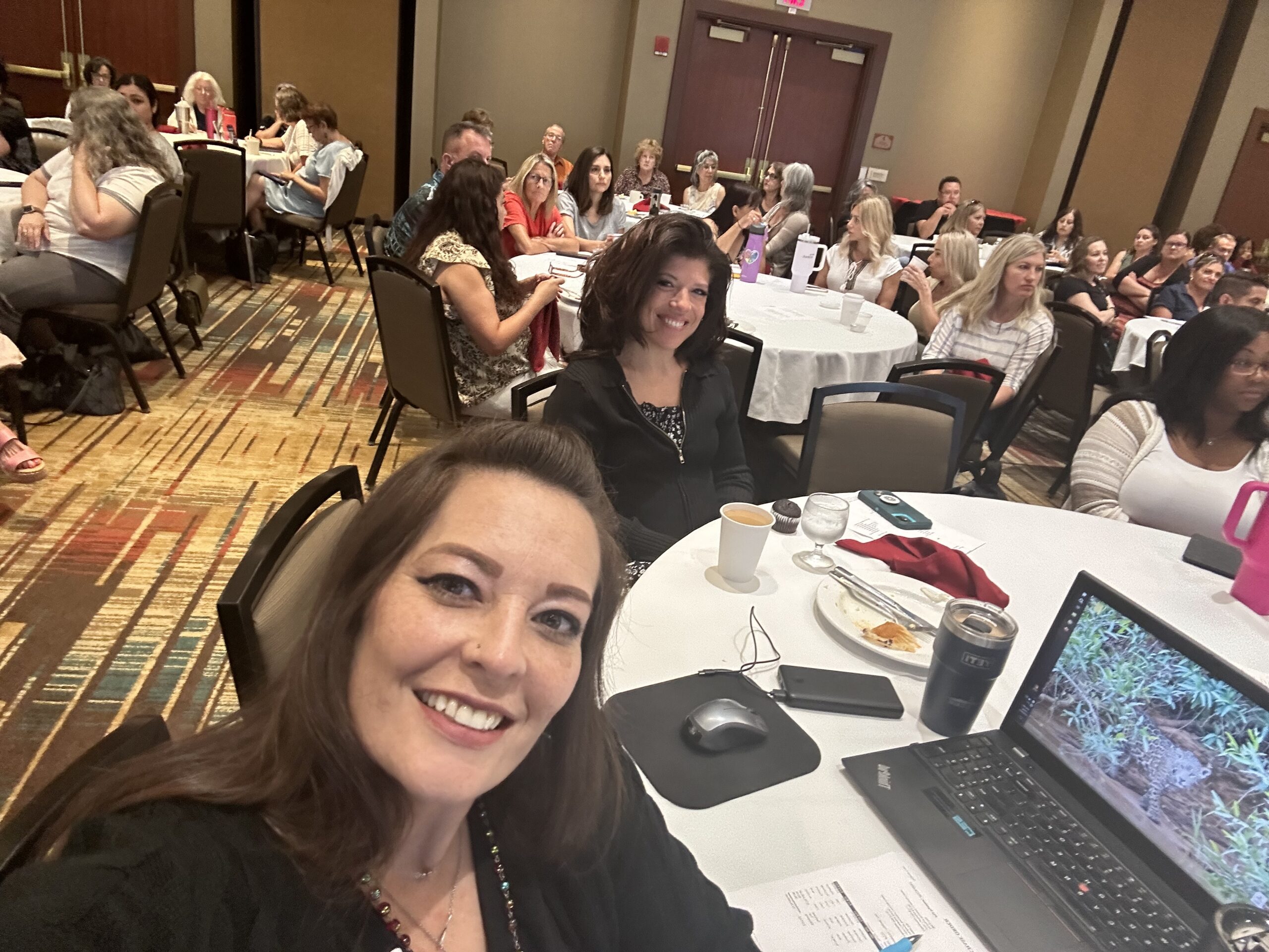 Meeting room of people smiling and listening to presenter